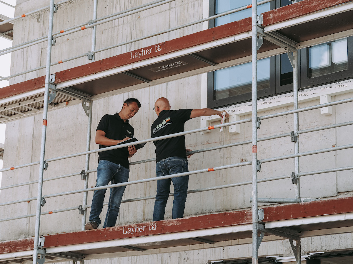 Zwei Energieberater von amcad Energieberatung auf Gerüst